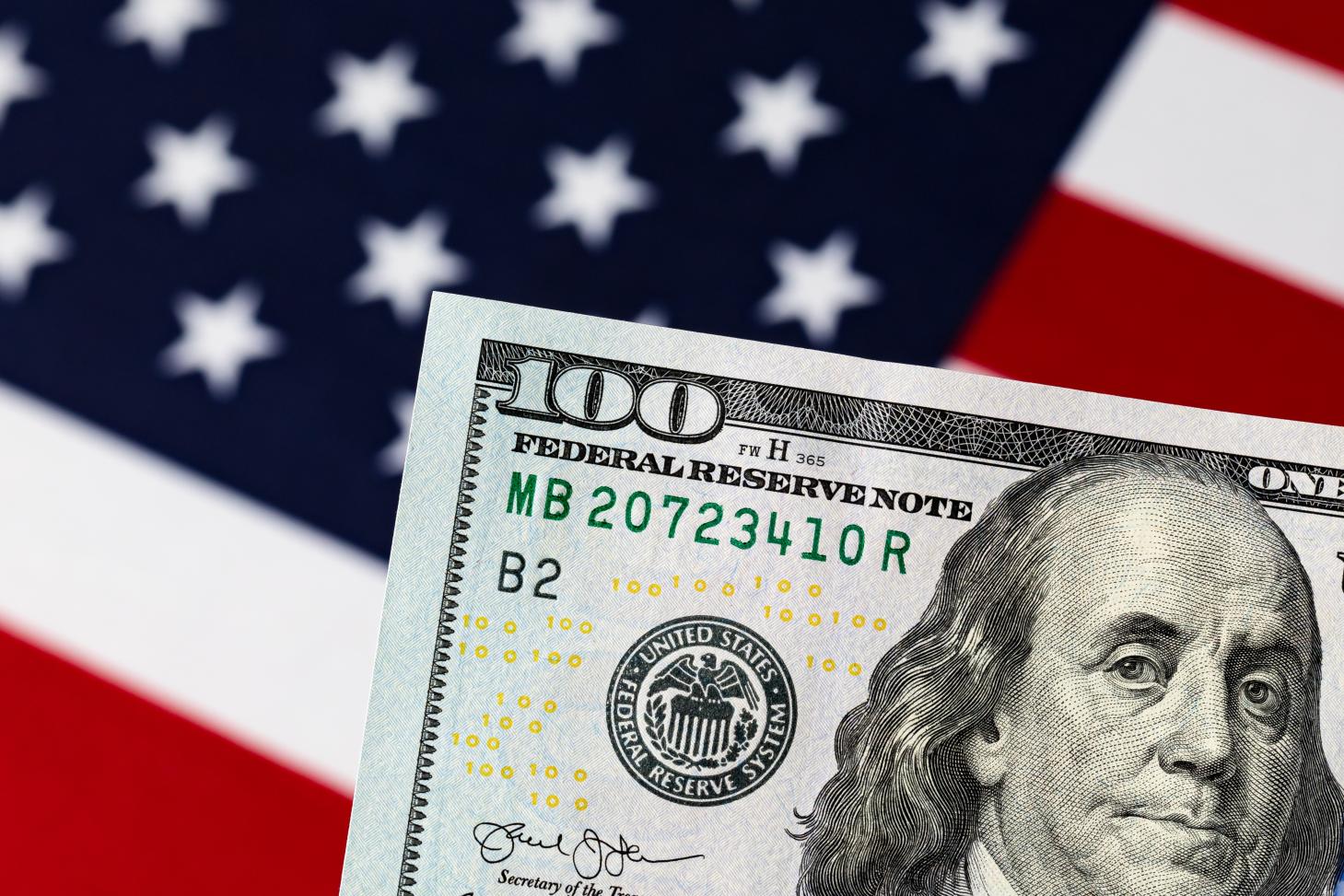An American flag and a 100 dollar bill