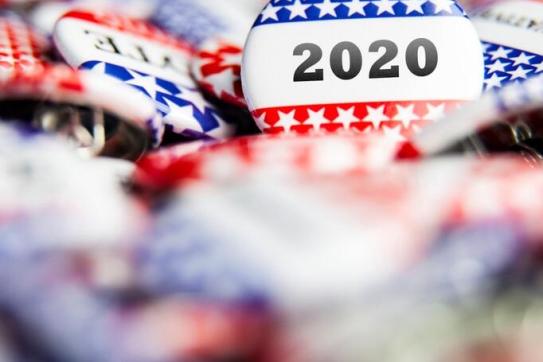 A pile of pins some that say, vote and some take 2020.