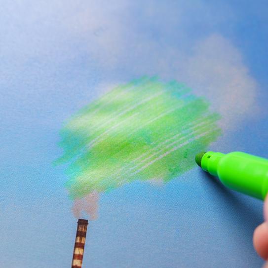A hand holding a green marker, coloring in gray smoke that's pouring out of a smokestack