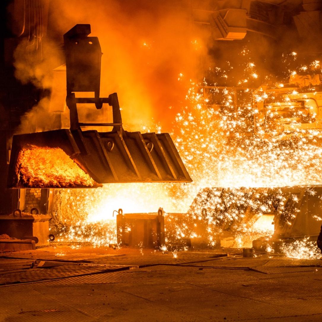 Steelworker near a blast furnace with sparks